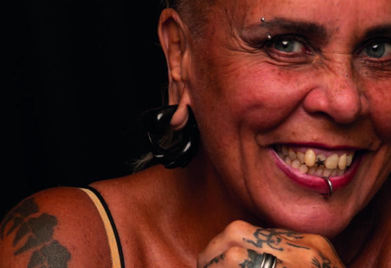 Kuvassa on Wilma Schlizewskin kasvokuva ja hän on ruskettuneena.  Kuvasta näkyy hänen paljasta olkapäätään, jossa on tatuointia.Hänellä on huulessa rengas ja samoin korvissa.