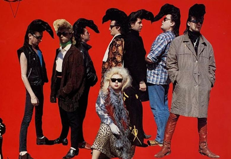 Kuvassa ovat Sleepy Sleepersin seitsemän miesjäsentä ja he seisovat parittain vastakkain ja yksi oikeassa reunassa. Heillä on etupäässä mustia vaatteita isot etuotsatukat. Edessä istuu vaaleassa tukassa ja tiikerikuvioisessa hameessa Tiina Tiikeri. Tausta on punainen. Kuva on osa levyn kannesta.