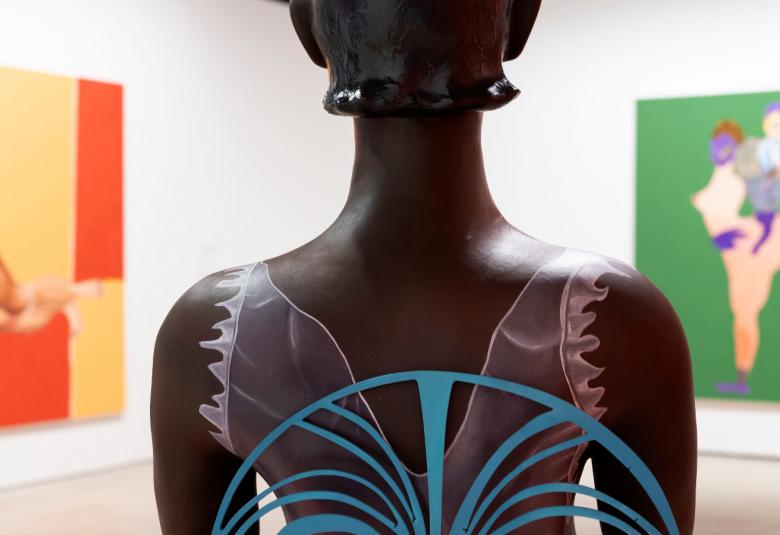 Kuvassa on takaa päin mustan naisen ylävartaloveistos ja siinä läpinäkyvä vaate, jossa on sinisiä raitoja pyöreästi ja perhosmaisesti. Vasemmalla on kelta-oranssi teos. Oikealla on vihreä pohjainen teos.