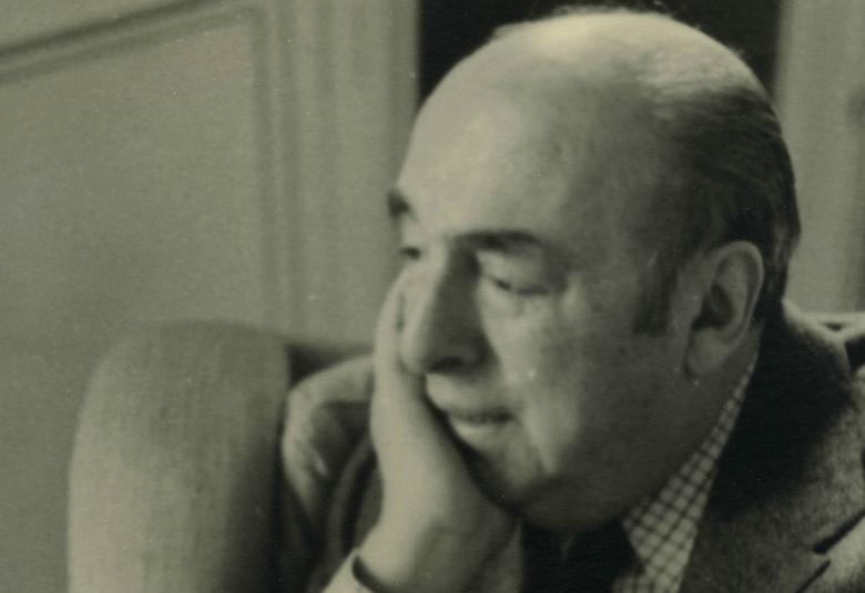 Kuvassa on Pablo Neruda istumassa sivuttain nojatuolissa ja oikea käsi poskellaan. Kuva on musta-valkoinen ja sävytetty ruskehtavaksi.
