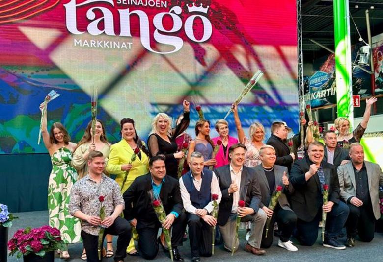 Kuvassa ovat 20 semifinaaliin päässyttä laulajaa yhteiskuvassa kahdessa rivissä kukkineen.  Eturivissä olevat miehet nojaavat toiseen polveensa ja naiset seisovat takana.