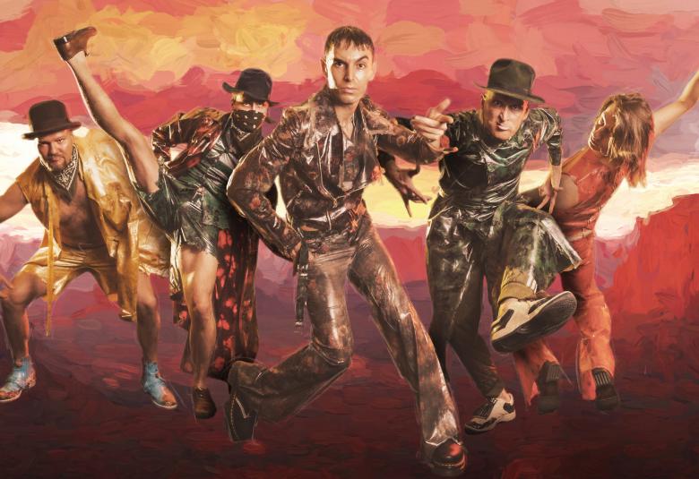 Kuvassa on lännen miesten tyyppisissä vaatteissa ja yhdellä on rosvovaatetus. Lisäksi on oikeassa reunassa yksi nainen punaisessa pitkässä puvussa.  Taustalla on oranssin punaista pilveä ja alla tummaa maata.