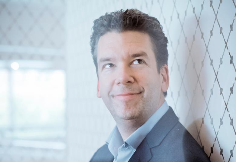 Kuvassa on Sebastian Fagerlund kasvokuvassa. Taustalta tulee valoa ja osa valosta on Fagerlundin kasvoilla. Oikealla näkyy vinoruutuista vaaleaa tapettia.