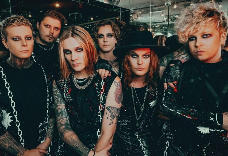 Kuvassa ovat Blind Channelin bändin kuusi jäsentä puolivartalokuvassa mustissa pusakoissa. Joissakin asusteissa on ketjujen kuvia.