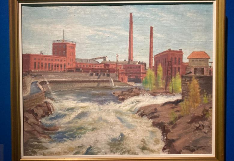 Kuvassa on taulu, jossa on punatiilinen tehdasrakennus ja sen edessä on pato sekä koski.