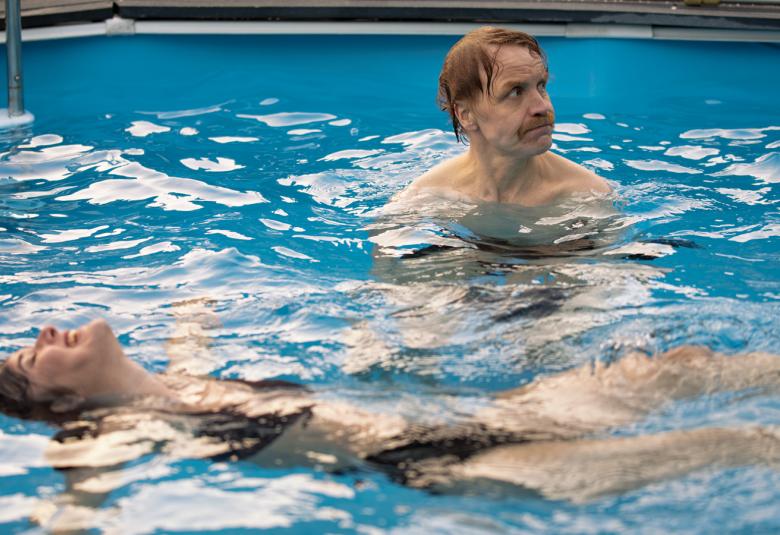 Kuvassa  on vasemmalla kellumassa sinisessä allasvedessä Aksa Korttila ja vieressä oikealla seisomassa vedessä Jani Volanen. Vesi aaltoilee hieman.