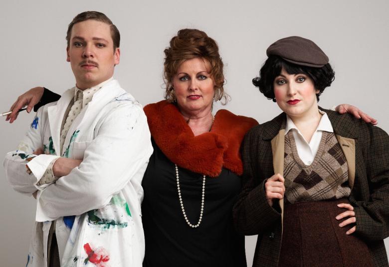 Kuvassa ovat Joonatan Perälä valkoisessa maalarin takissa, Leena Rousti mustassa mekossa tumman punaisella puuhkakauluksessa ja Sanni Lehto mustassa takissa ja puolihameessa. Tausta on vaalea.