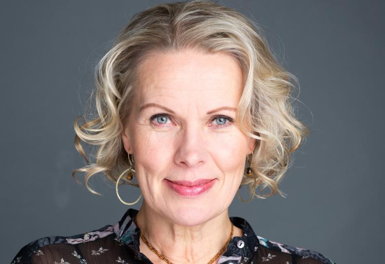 Kuvassa on Niina Honkanen kasvokuvassa. Hänellä on vaaleat hieman kiharat, lyhyehköt hiukset. Tausta on harmaa.