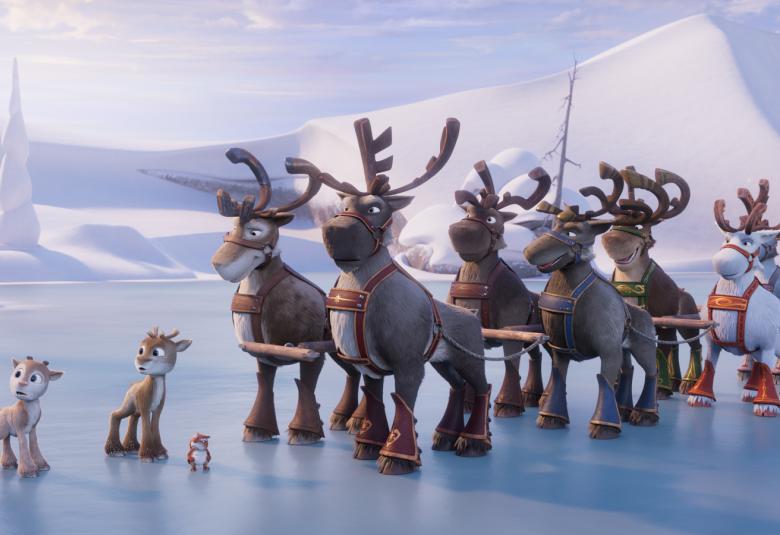 Kuvassa on jäällä vasemmalla kaksi pikkuporoa.  Oikealla on porolauma.  Taustalla luminen terävä tunturi.  