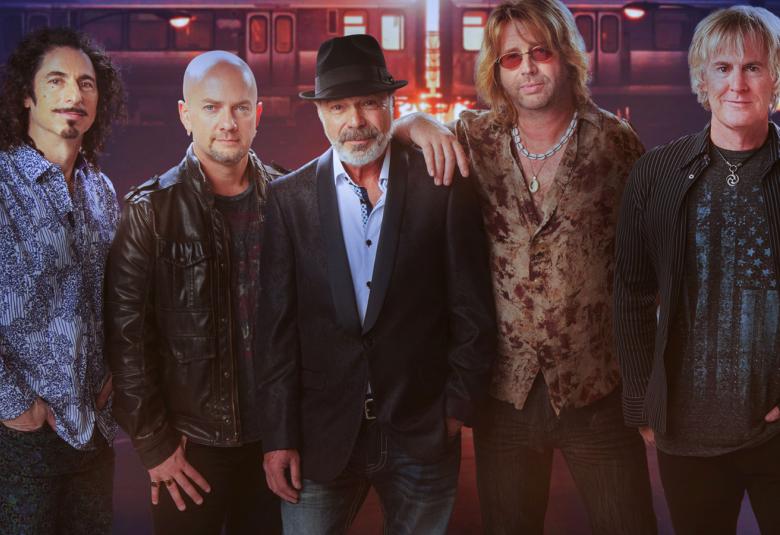 Kuvassa on Chicago Experiencen viisi miesjäsentä.  Heillä on kaikilla erilaiset, tummahkot vaatteet. 