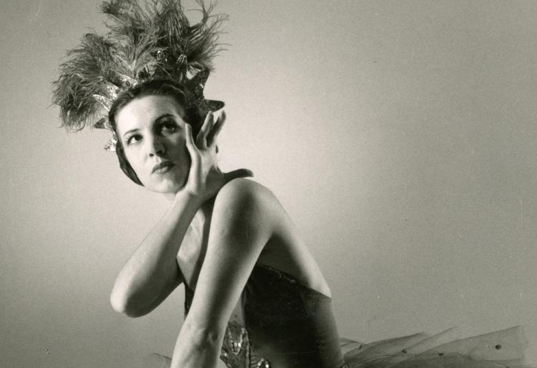 Kuvassa on Elsa Sylvestersson tanssimassa balettia ja hänellä on töyhtöpäähinen päässään ja balettihame. Oikea käsi on kiedottu vasemmalle olkapäälle. Kuva on musta-valkoinen.