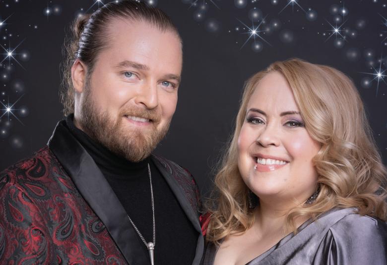 Kuvassa ovat Teemu Roivainen ja Hanna Kinnunen rinnakkain puolivartalokuvassa. Taustalla on tummaa tähtitaivas-lavastusta.