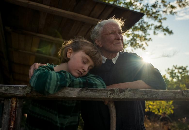 Kuvassa on nuori Sophia Matthews, joka nojaa Glenn Glosen olkapäähän ja jota hän pitää Matthewsin olkapäästä kiinni hirsimökin terassilla. Taustalta mökin katon takaa paistaa himmeästi aamuaurinko.