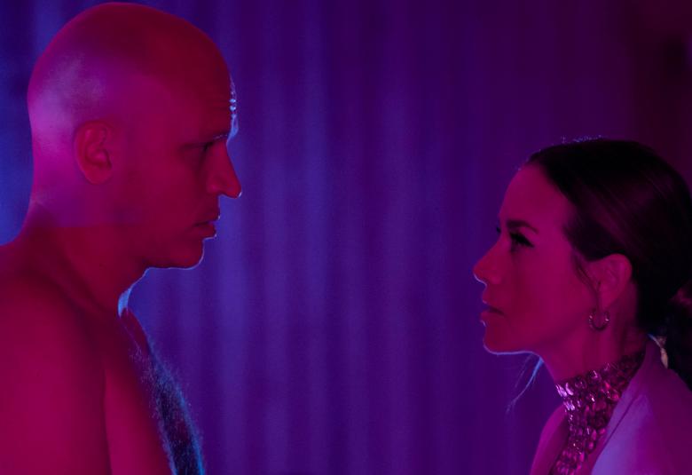 Kuvassa ovat Riku Nieminen ja Iina Kuustonen seisomassa vastakkain puolivartalokuvassa. Kuvan tausta on sininen ja se on sävytetty kokonaan punaisella.