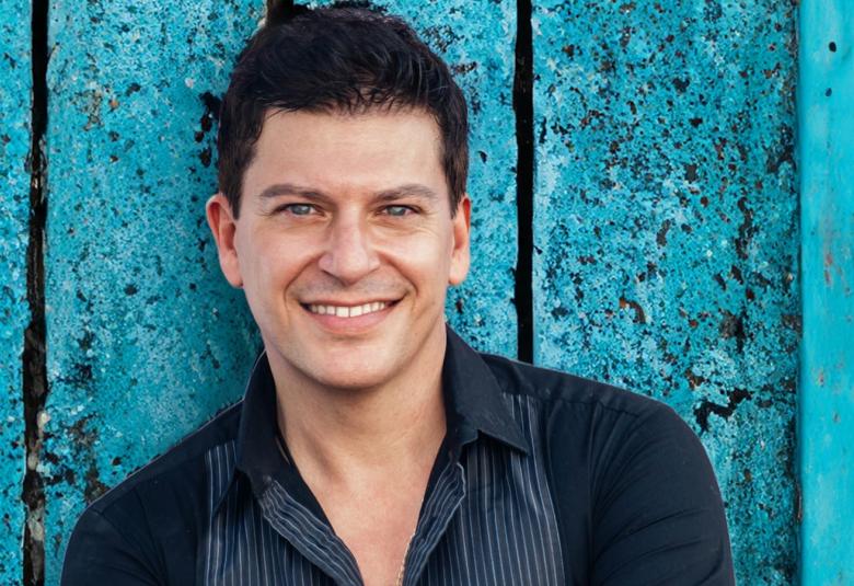 Kuvassa on Patrizio Buanne puolivartalokuvassa mustassa paidassa.  Taustalla on sinistä puuseinää.