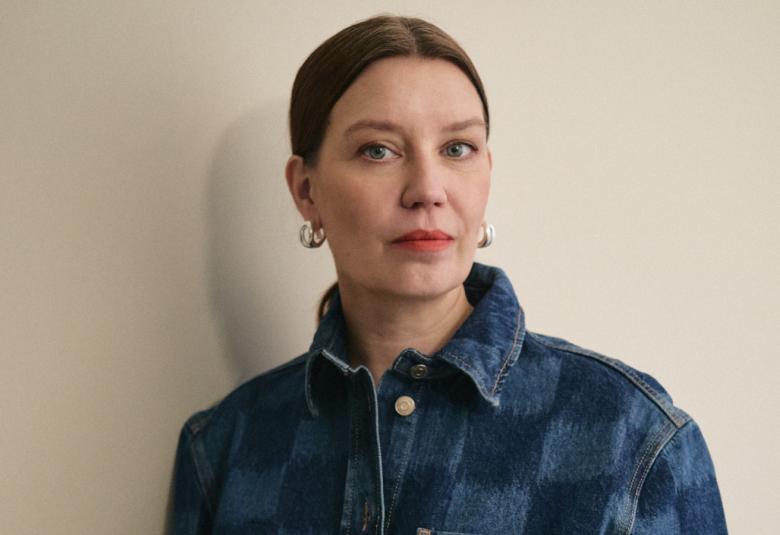 Kuvassa Päivi Helander kasvokuvassa ja hänellä on tummat hiukset siduttuna taakse. Hänellä on sininen farkkutakki.