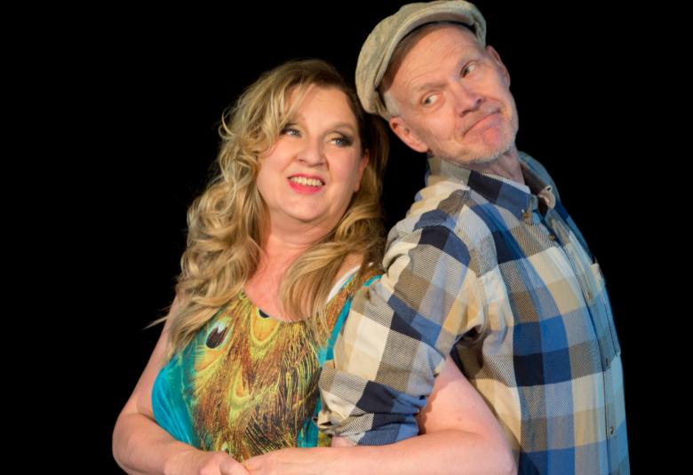 Kuvassa Marja-Liisa Turunen vasemmalla kirjavassa mekossa ja oikealla siniruutuisessa paidassa ja lippalakissa Juha Koljonen. He ova puoliksi selät vastakkain ja Turusen toinen käsi Koljosen kainalossa.