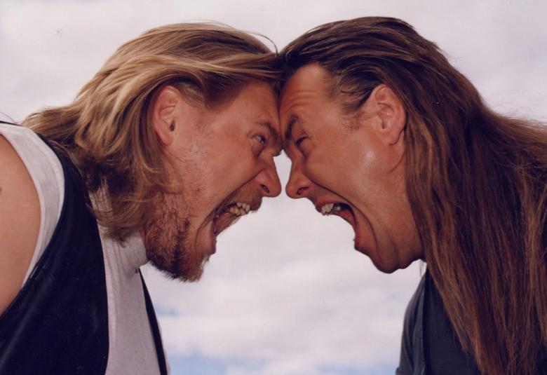 Kuvassa ovat Samuli Edelmann ja Juha Veijonen puolivartalokuvassa otsat vastakkain huutamassa toisilleen. 