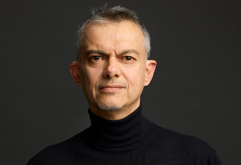 Kuvassa on Javier Torres puolivartalokuvassa ja hänellä on musta paita päällään.  Tausta on tumma.