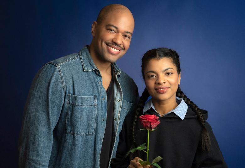 Kuvassa on Matti Leino vasemmalla sinisessä farkkupuserossa. Hänen vieressään on Yasmine Yamajako, joka on lyhyempi ja hänellä on tumman sininen pusero sekä punainen ruusu kädessään.  Tausta on tumma.