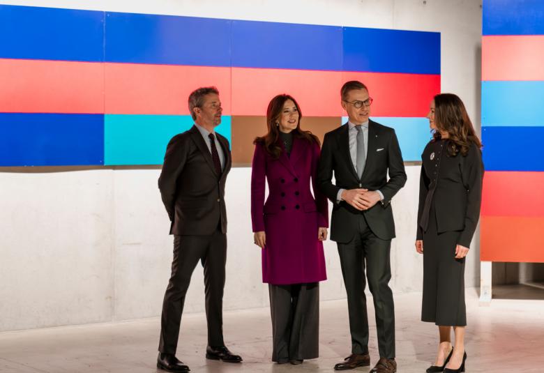 Kuvassa ovat vasemmalta Tanskan kuningas Frederik X ja kuningatar Mary violetissa takissa sekä Alexander Stubb ja Suzanne Innes-Stubb tummassa mekkossa. Taustalla ovat seinällä teokset, joissa on palkit, joista päällimmäinen on kirkkaan sininen ja seuraava punertava. Alla olevassa palkissa on useita  värejä. Viereisellä seinällä tasaisten palkkien teos.