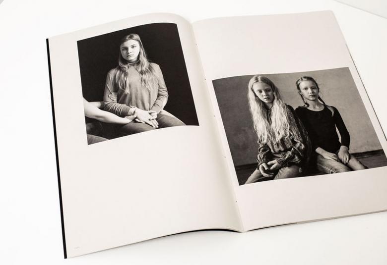 Kuvassa on vinosti valokuvakirja ja sen aukeama. Vasemmalla sivulla on kuva nuoresta tytöstä istumassa ja hänellä on pitkät hiukset. Hänen vasemmalta puolellaan näky kädet hänen oikeassa kainalossaan ja ranteessaan. Oikealla sivulla on kuva sisaruksista, jotka istuvat ja vasemmalla on tyttö vaaleissa pitkissä hiuksissa. Oikealla on tyttö leteissä ja tummassa puserossa. Kuvat ovat musta-valkoisia.