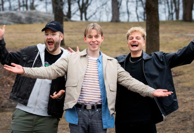Kuvassa ovat kädet levitettynä sivulle vasemmalta Santeri Hänninen, Niko Meuronen ja Heny Weckström. Taustalla on mäki, jossa näkyy puunrunkoja. 