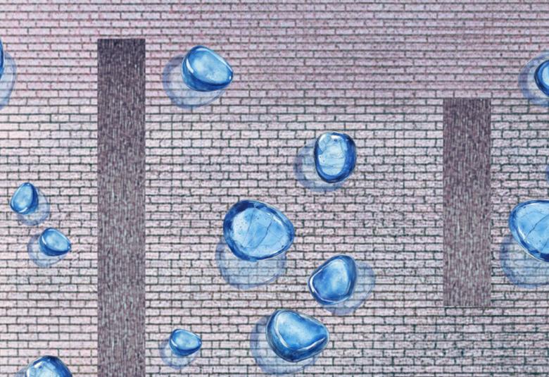 Kuvassa on harmaata tiiliseinää, jossa kolme kapeata pystyä pylväsmäistä kuviota seinässä. Kuvassa on sinisiä, lasisia leijuviä pyörylöitä.