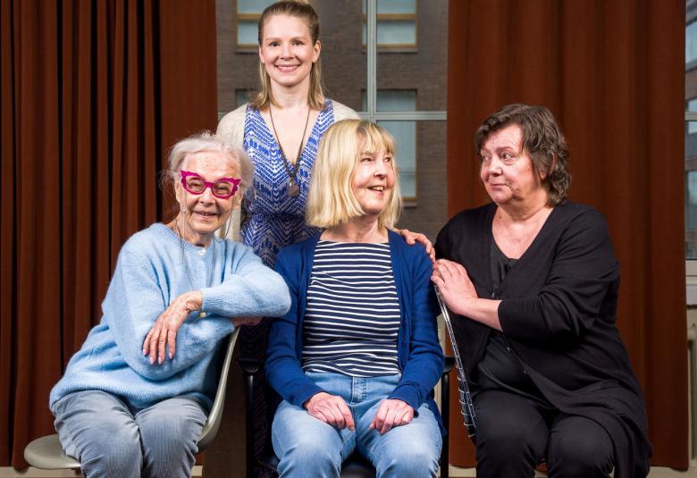 Kuvassa ovat alhaalla istumassa vasemmalta Seela Sella vaalean sinisessä puserossa, Leena Uotila sinisessä villatakissa ja Sanna-Kaisa Palo mustassa villatakissa. Takana seisoo Pamela Tola sinisessä, hihattomassa puserossa. Taustalla on ruskeaa verhoa.