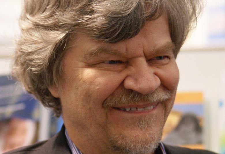 Kuvassa on M.A. Nummisen kasvot ja hänellä on puolipitkät, vaaleahkot taipuisat hiukset.