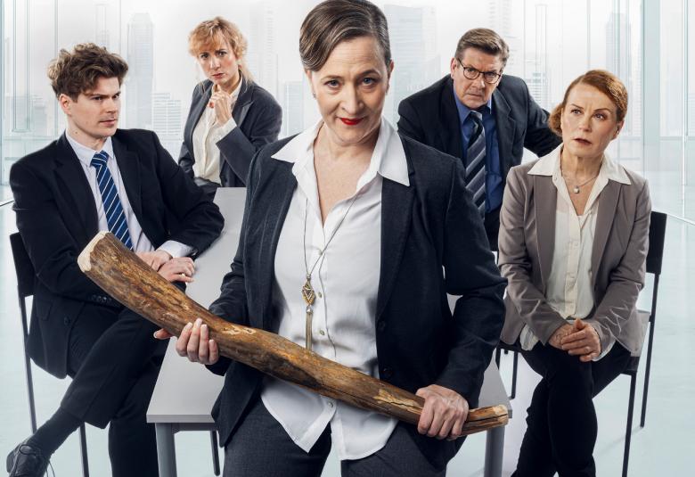 Kuvassa ovat pöydän ääressä tumman sinisissä puvuissa ja valkoisissa paidoissa Martti Manninen, Sanna-June Hyde ja Santeri Kinnunen sekä harmaassa puvussa ja valkoisessa paidassa Ursula Salo. Keskellä edessä on Wanda Dubiel tumman sinisessä puvussa ja valkoisessa paidassa. Tausta on vaalea.