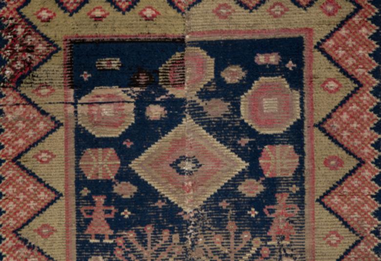 Kuvassa on osa vanhasta ryijystä, jossa on reunoissa sahalaitakuviotamustalla reunuksella ja ruskeaa tähtikuviota. Keskellä on leveä alue eialisia kuvioita vihertävällä ja ruskealla värillä.