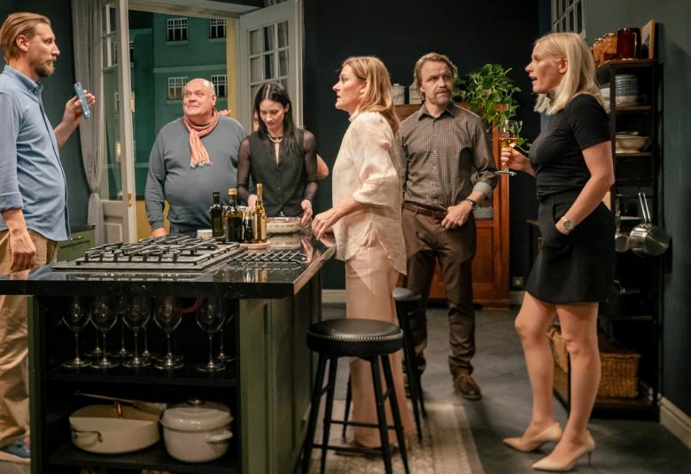 Kuvassa ovat vasemmalta Pekka Streng vaalean sinisessä paidassa, Hannu-Pekka Björkman, Malla Malmivaara, Pirjo Lonka, Jani Volanen ja Laura Birn. Keskellä on pöytä, jonka ympärillä kaikki seisovat. 