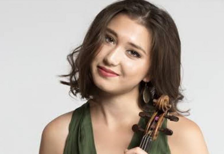 Kuvassa on Tami Pohjola, joka on pää hieman oikealle taivuteltuna. Hänellä on tummat puolipitkät hiukset.  Hänellä on vihreä, hihaton mekko. Hän pitää viulua kädessään. Tausta on vaalea.