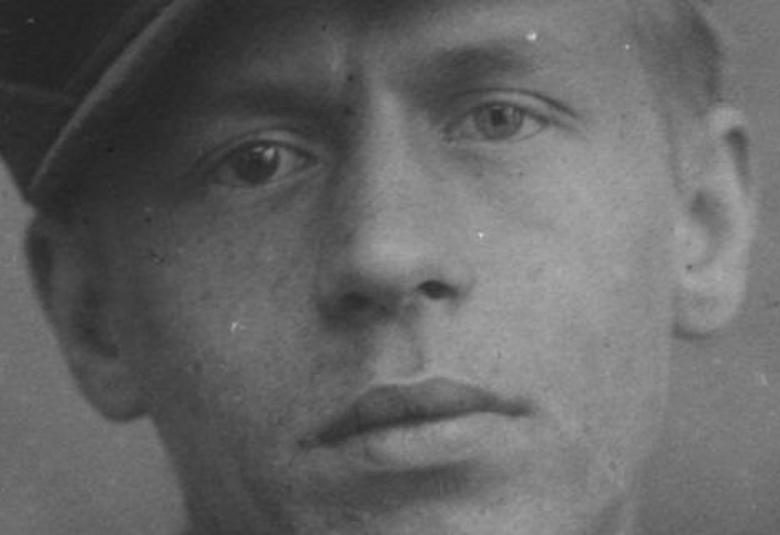 Kuvassa on Jalmari Ruokokosken kasvot musta-valkokuvassa. Hänellä on lippalakki päässään. Kuvan sävy on harmaa.