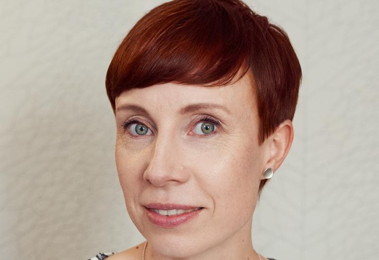 Kuvassa on Riikka Tuohimetsä kasvokuvassa. Hänellä on punaiset, lyhyet hiukset.