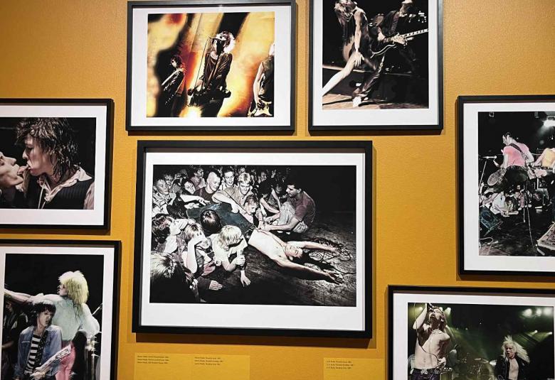 Kuvassa on kellertävällä seinällä musta-valkoisia kuvia. Keskellä olevan ympärillä on kuusi pienempää kuvaa.