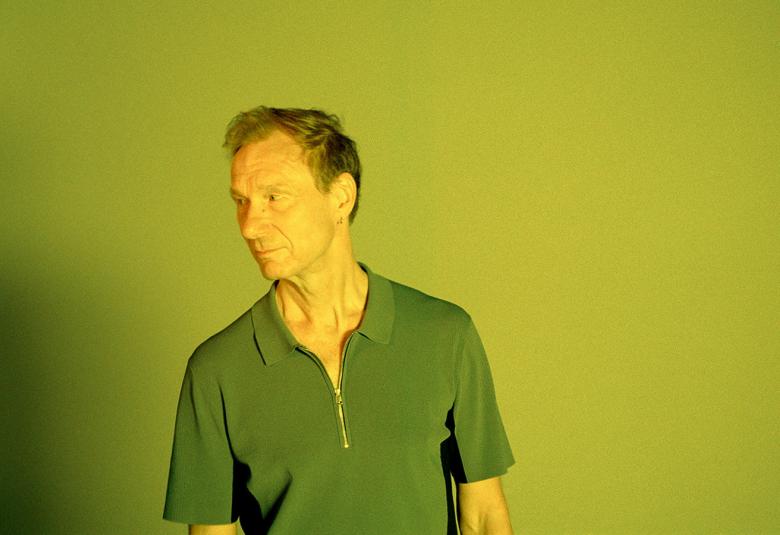 Kuvassa on Ismo Alanko puolivartalokuvassa ja hänellä on vihreä lyhythihainen pusero päällään.  Tausta ja kuvan sävy on vihreä.