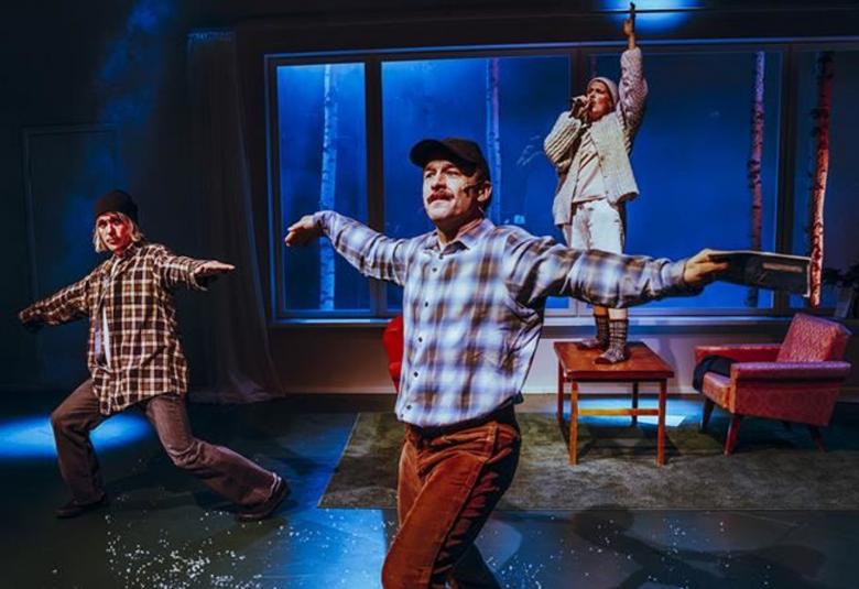 Kuvassa on vasemmalla nuori mies ruutupaidassa tanssiasennossa kädet levitettyinä sivulle ja polvet taivutettuina. Hänellä on ruskea-valkoinen ruutupaita päällään. Keskellä edessä on mies vaalean ruskearuutuisessa paidassa. Taustalla on nuori mies seisomassa tuolin päällä vaaleissa vaatteissa. Taustalla on ikkuna ja kuvan sävy on tumman sininen.