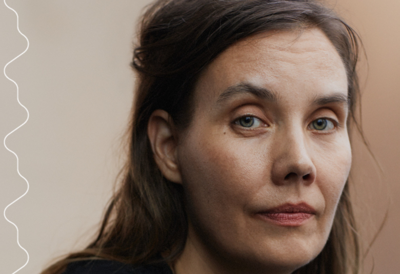 Kuvassa on keskellä lattialla makaava nainen ja häntä hoitaa toinen nainen. Molemmin puolin seisoo jonossa miehiä ja naisia ja heillä on tavalliset vaatteet. Tausta on tumma.