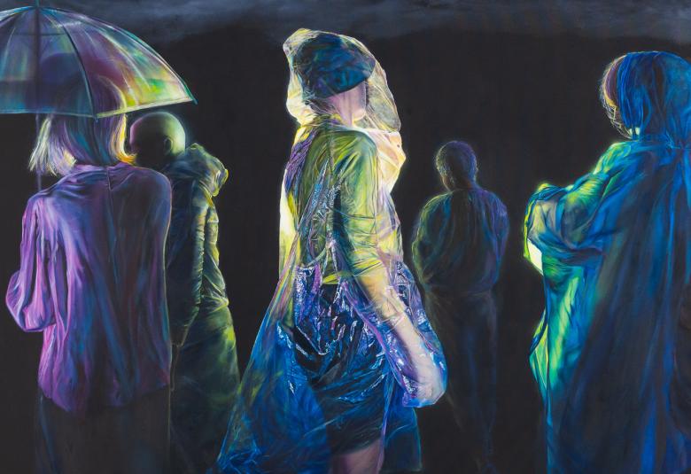 Kuvassa on ihmisiä kertakäyttösadetakit päällään ja näkyy hieman valoa pimeässä. Vasemmalla olevalla naisella on sateenvarjo ja hän on selin. 