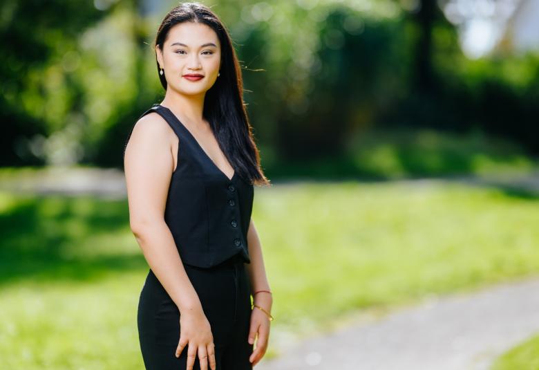 Kuvassa on Jingjing Xu seisomassa mustassa hihattomassa mekossa. Taustalla on vihreätä puistoa.