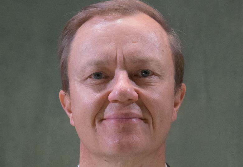 Kuvassa on Mika Nuojua kasvokuvassa. Tausta on harmahtava.