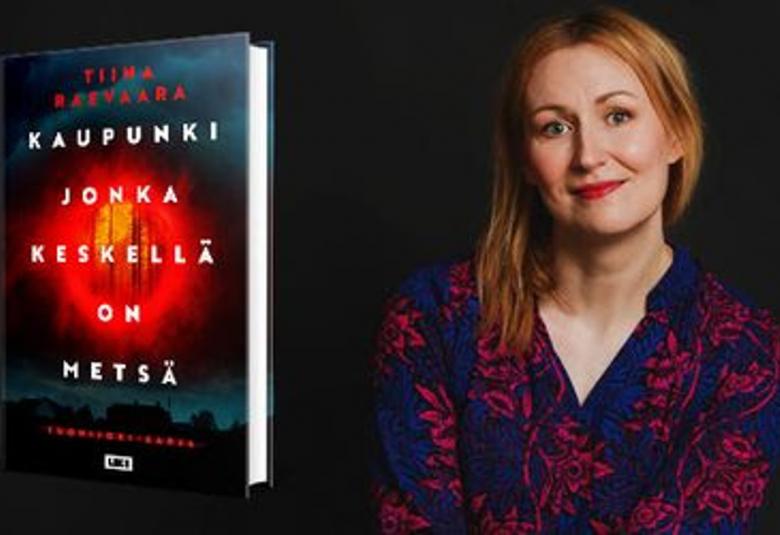 Kuvassa on vasemmalla kirjan kansi ja siinä monella rivillä kirjan nimi valkoisella Kaupunki jonka keskellä on kylä. Tausta on tumma ja siinä on punainen pyörylä keskellä. Oikealla on Tiina Raevaara ja hänellä on mustaä pusero päällään. Kuvan tausta on musta.