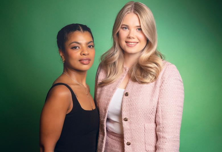 Kuvassa on vasemmalla Yasmine Yamajako mustassa hihattomassa t-paidassa. Hänen vieressään oikealla seisää vaalean punaisessa jakussa Nomi Enckell. Tausta on vihreä.