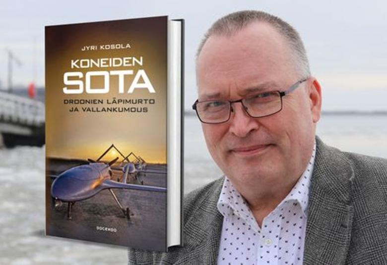 Kuvassa on oikealla Jyri Kosola puolivartalokuvassa ja hänellä on harmaa takki sekä valkoinen, musta pilkullinen paita päällään. Taustalla lumista maastoa ja vasemmala harmaa rakennus. Vasemmalla on kirjan kansi, jossa on kirjan nimi suurin valkoisin kirjaimin ja auringonlaskun taivaan alla rivissä harmaita drooneja.