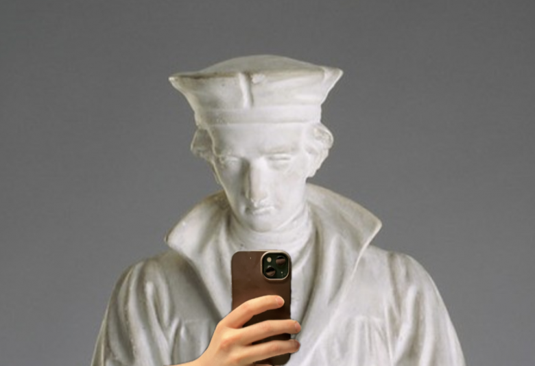 Kuvassa on Mikael Agricolan valkoinen patsas, jossa hänellä on pää kumartuneena hieman alaspäin. Hänen edessään on käsi, jossa on kännykkä.