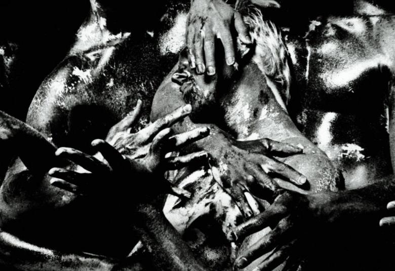 Kuvassa on sekavasti käsiä ja jalkoja sekä ruumiin osia sekavasti kasassa. Kuva on musta-valkoinen.