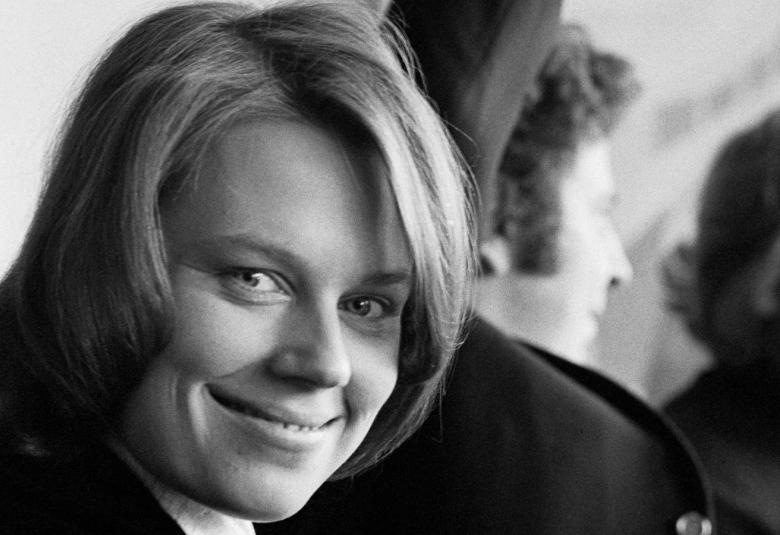 Kuvassa on Arja Saijonmaa nuorena kasvokuvass. Taustalla näkyy Mikis Theodorakis selin ja osaa kasvoista. Kuva on musta-valkoinen.