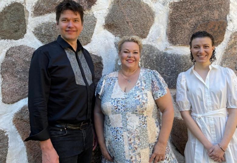 Kuvassa on vasemmalta Jussi Makkonen mustassa puserossa ja mustissa farkuissa. Vieressä on Johanna Rusanen-Kartano vaalean sini-valkoisessa mekossa ja oikealla Nazig Azezian valkoisessa mekossa.